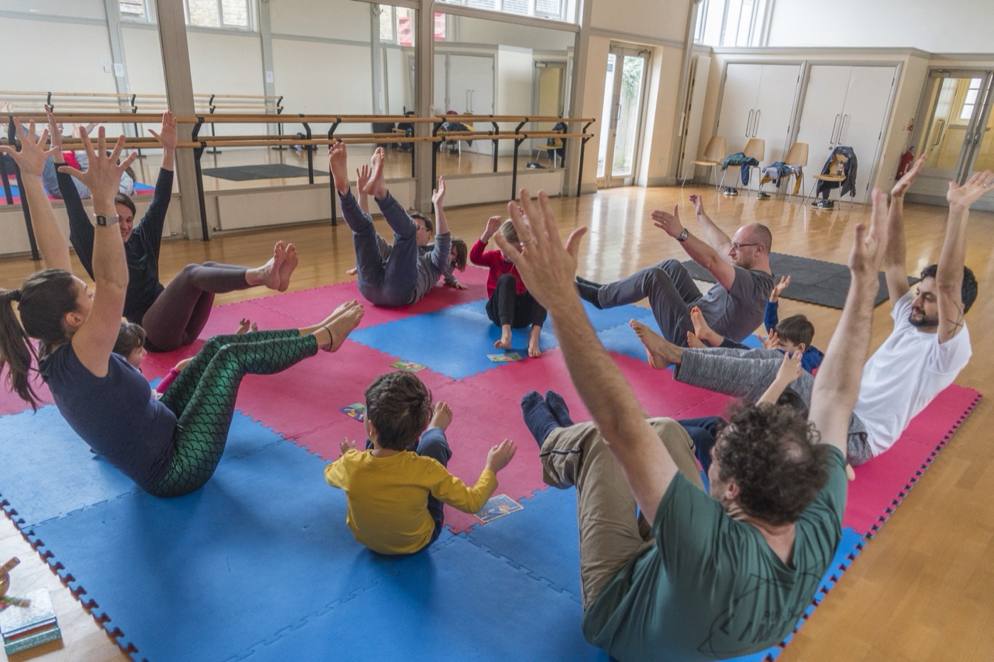 Bambini e genitori in movimento durante una sessione di yoga in famiglia